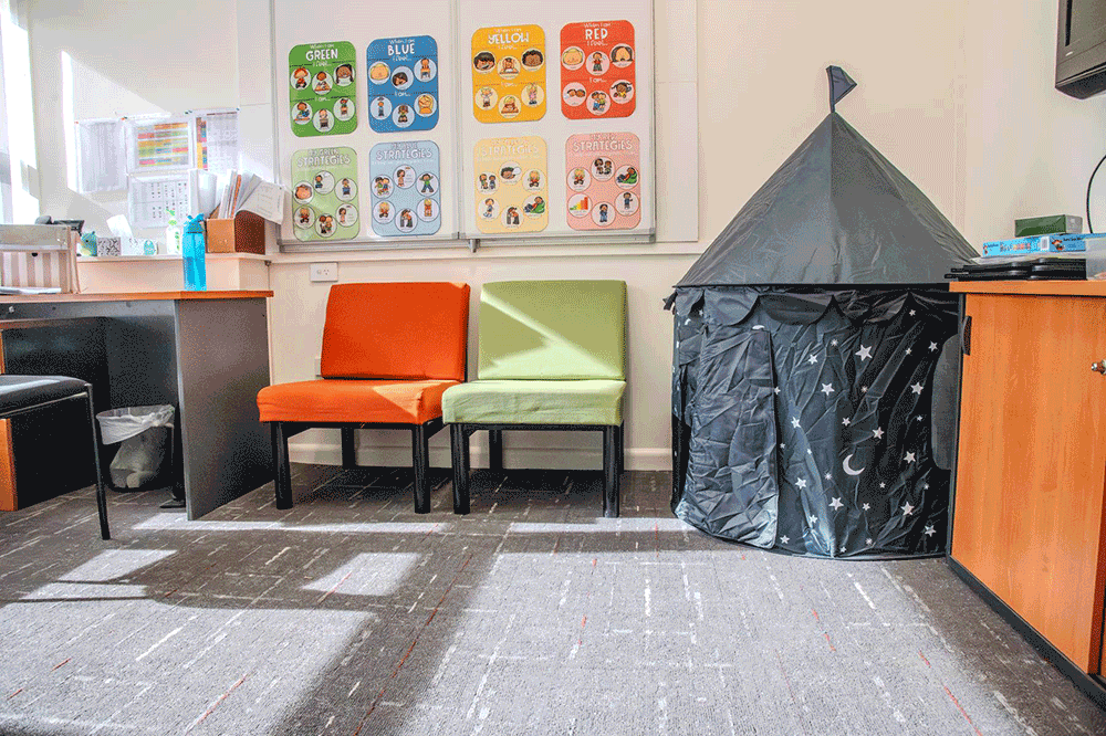 inside room with carpet floors, natural light, a pop up children's tent and two colourful chairs.