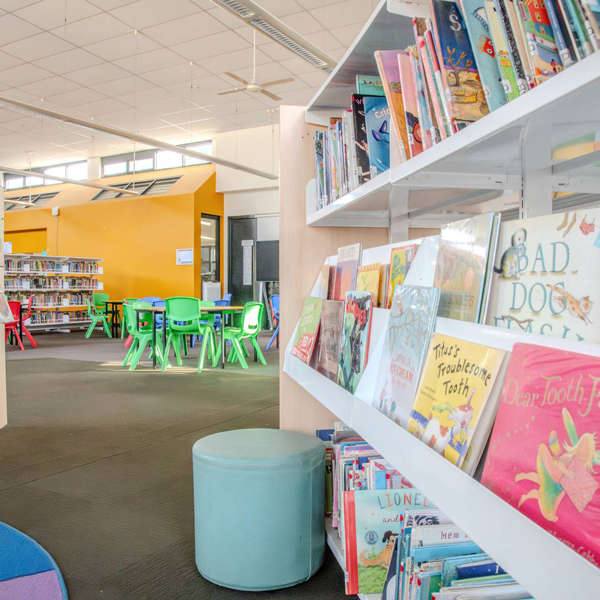 books on shelves in a library with colourful walls and furniture